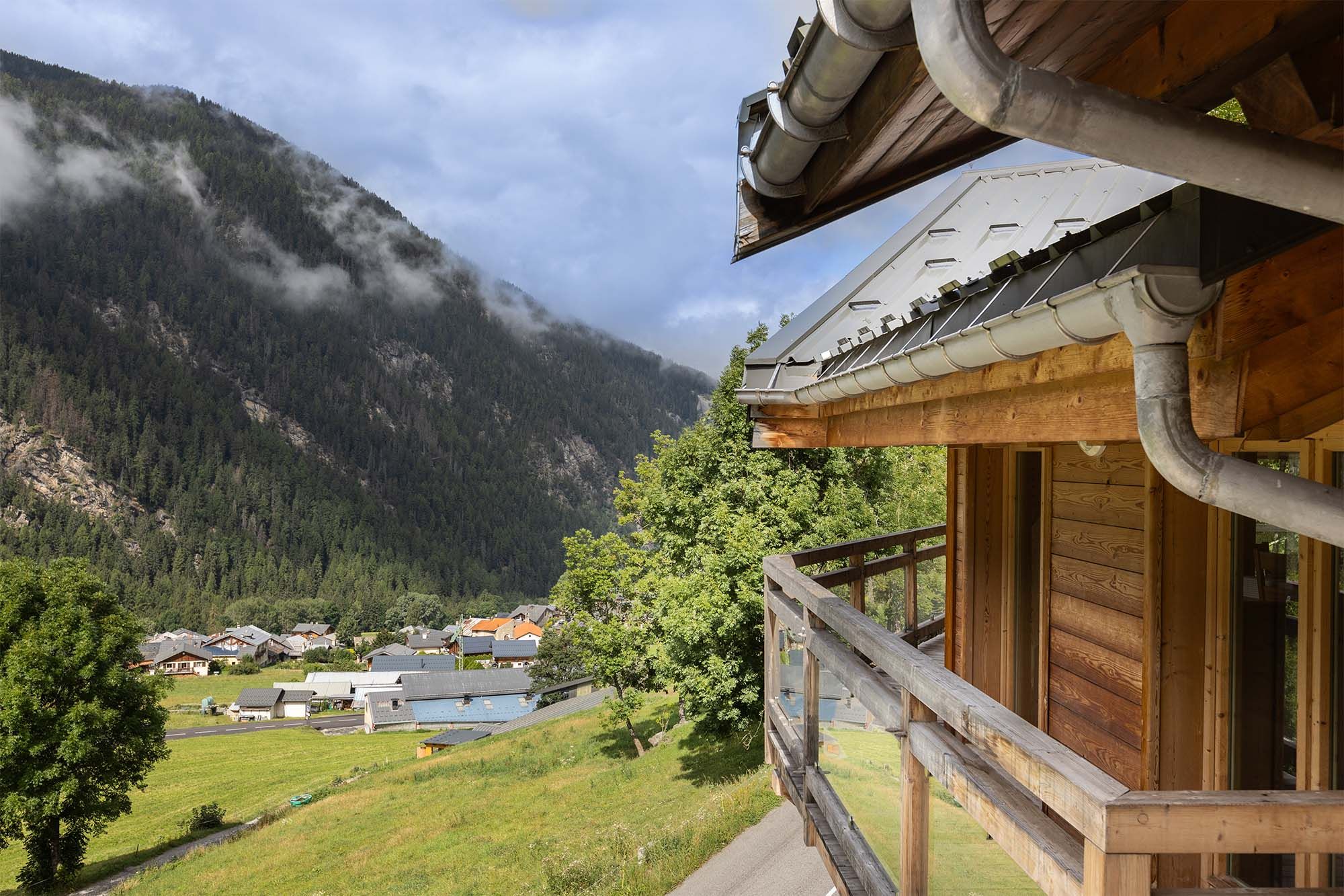image Enjoy serene views of the valley and mountains from this wooden balcony, offering a peaceful space to relax and take in the natural beauty surrounding the property.
