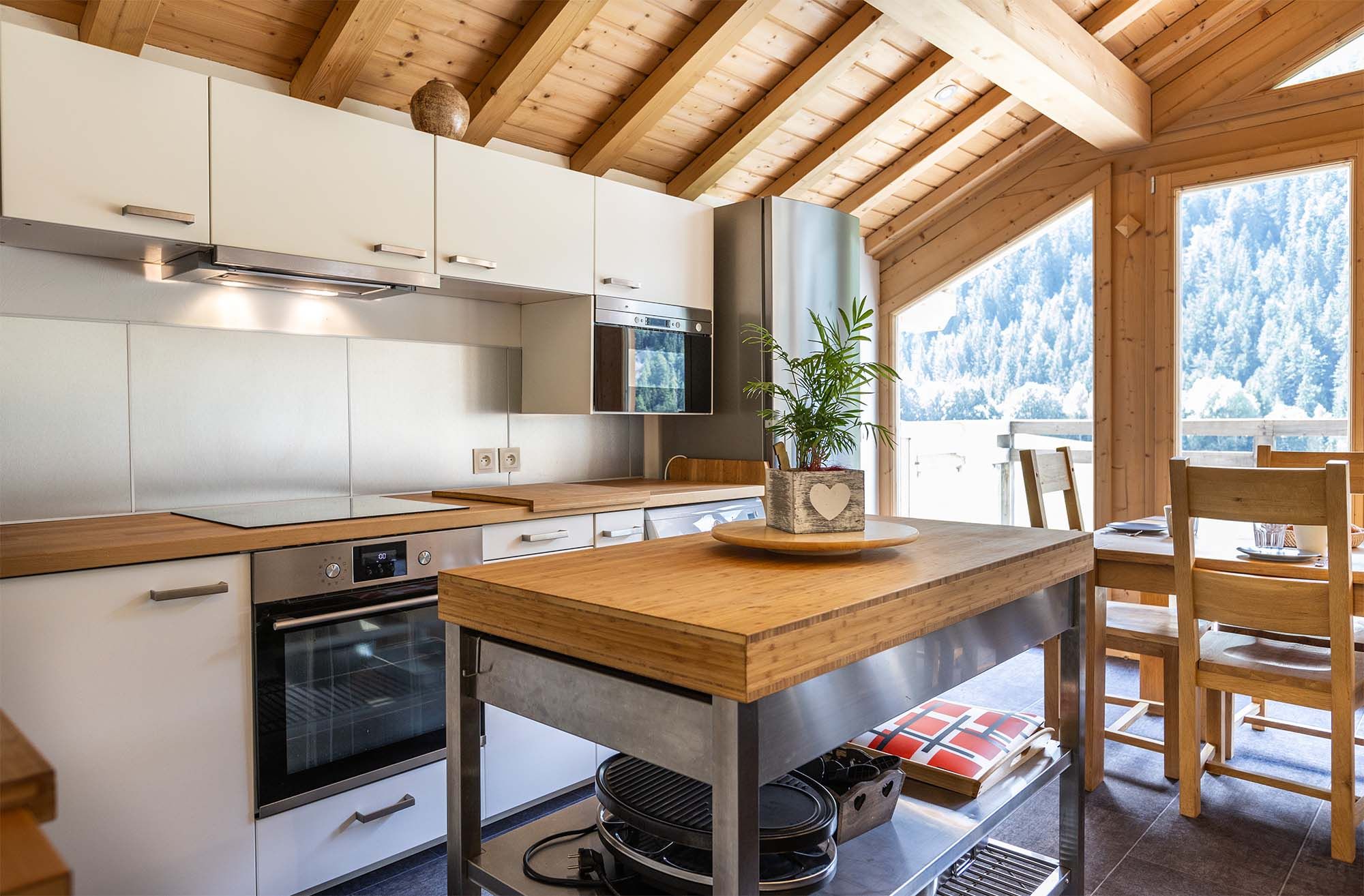image This fully equipped kitchen combines modern appliances with rustic wooden finishes, providing a beautiful and functional space for meal preparation. Large windows offer scenic views to enjoy while cooking.