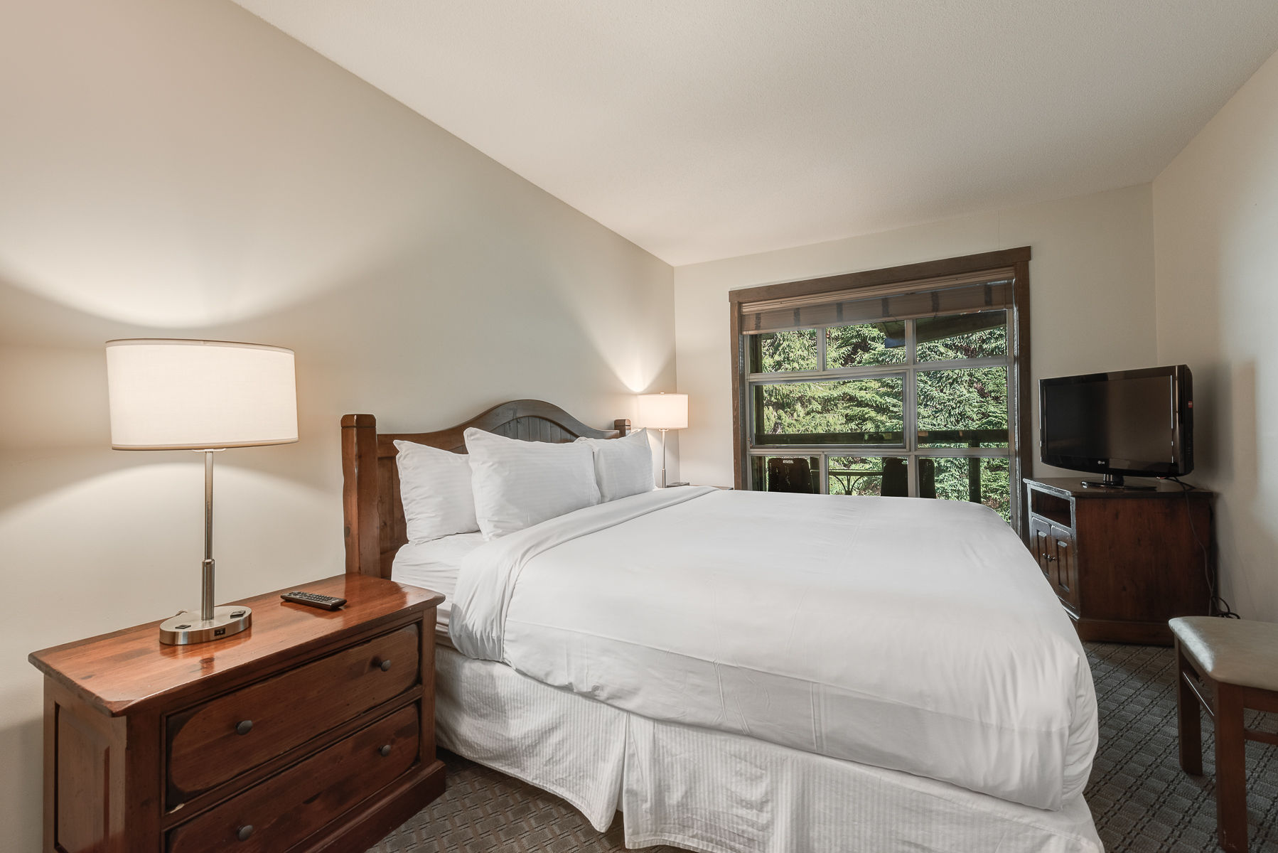 image Bright bedroom with a comfy bed and peaceful outdoor views.