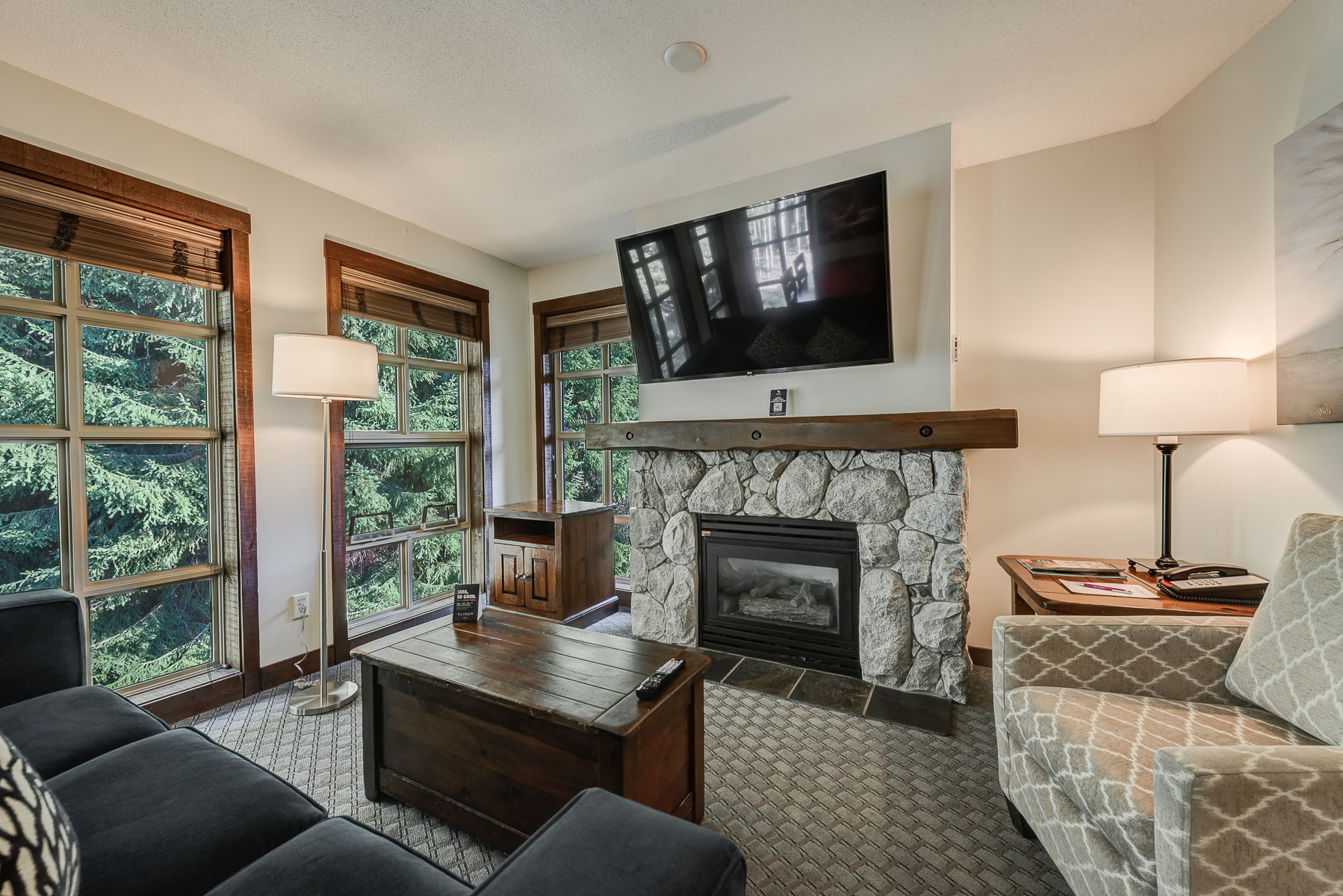 image Cozy seating area with large windows and a TV, perfect for relaxing.