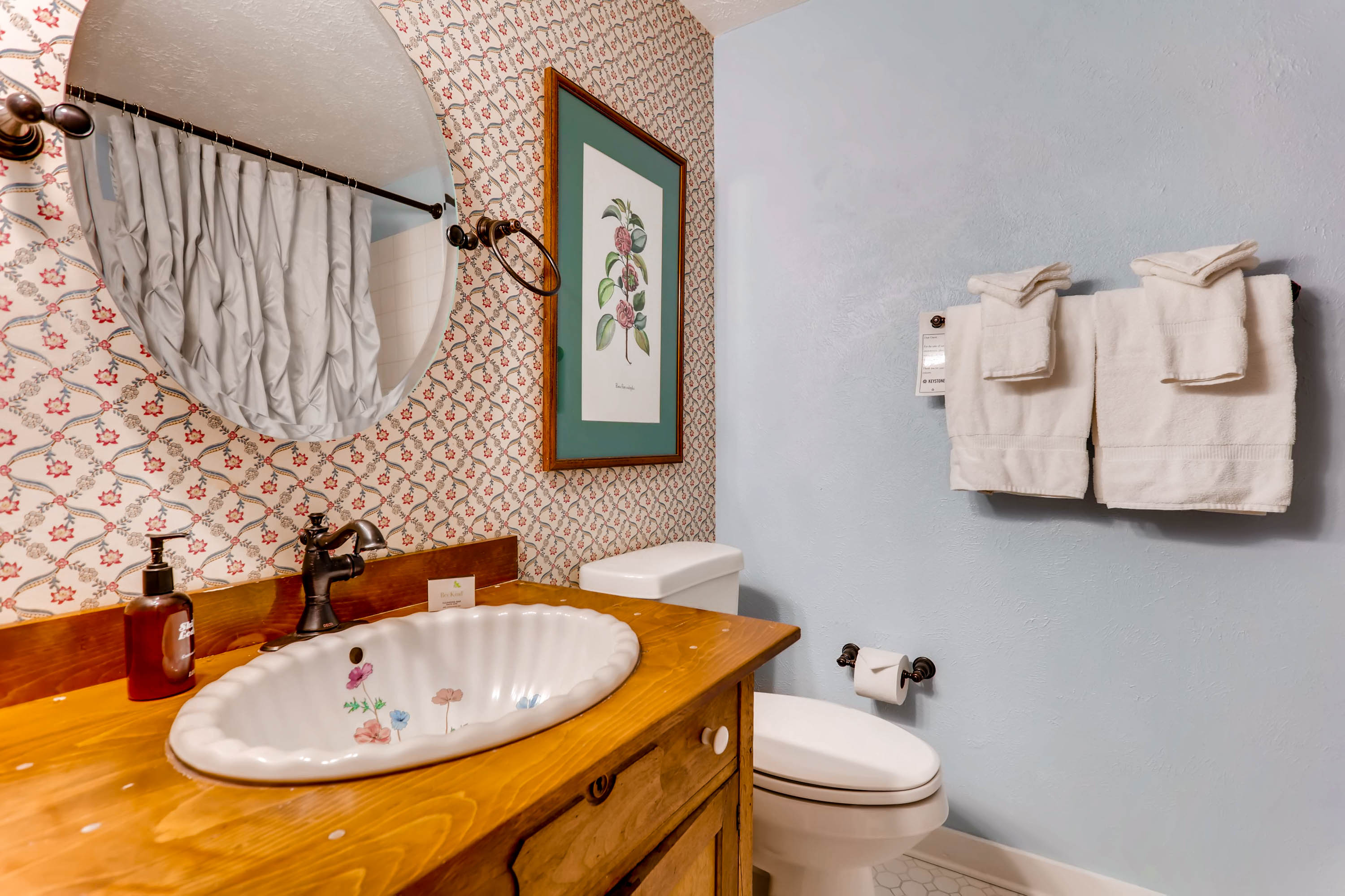 image Playful vintage-inspired bathroom with a colorful backsplash and warm wooden vanity, full of character.