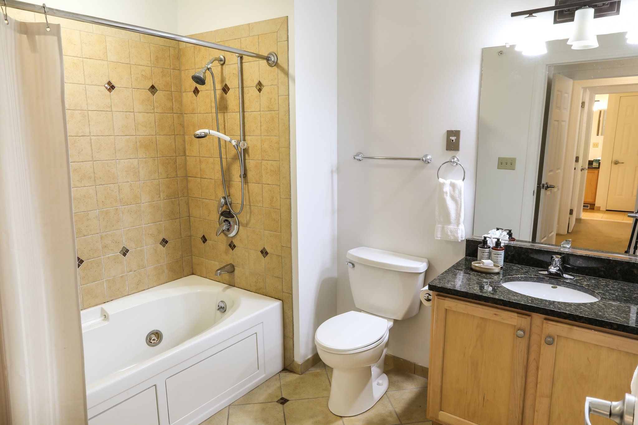 image Clean and modern bathroom featuring a shower-tub combo and sleek finishes for convenience and comfort.