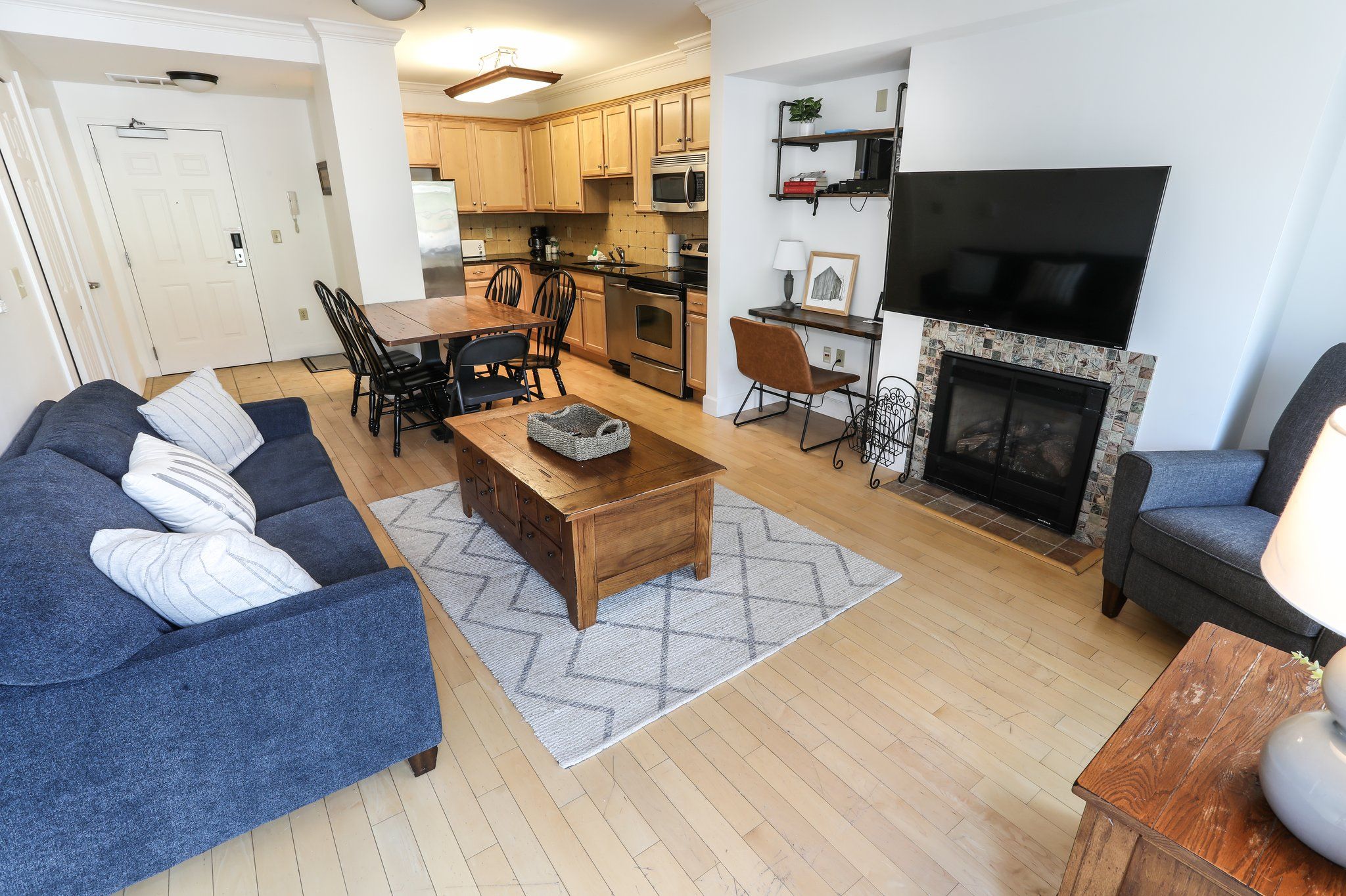 image Inviting living room with comfortable seating, a fireplace, and a flat-screen TV for relaxation and entertainment.