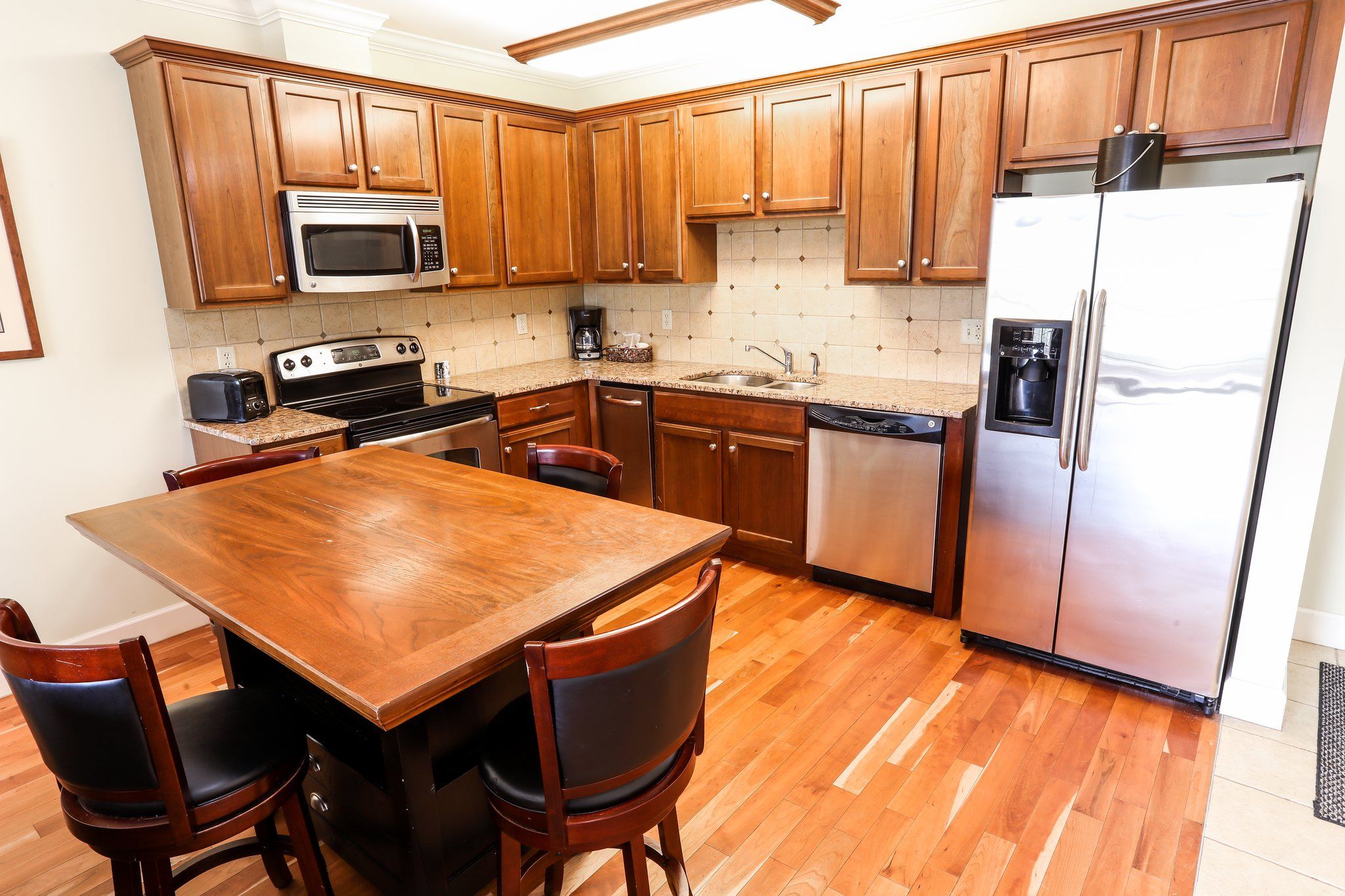 image Fully equipped kitchen with modern appliances and a dining area for enjoying home-cooked meals.