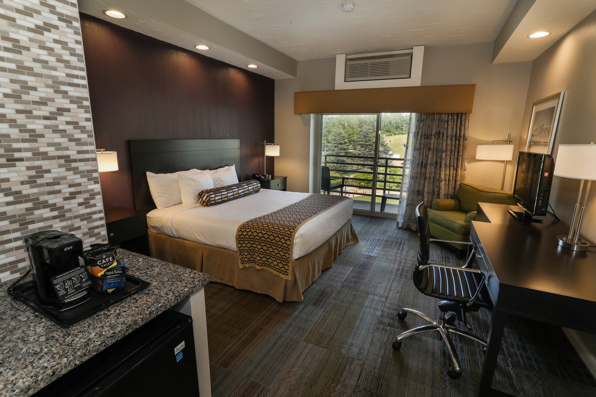 image Comfortable guest room with a plush bed, work desk, and plenty of natural light from large windows.