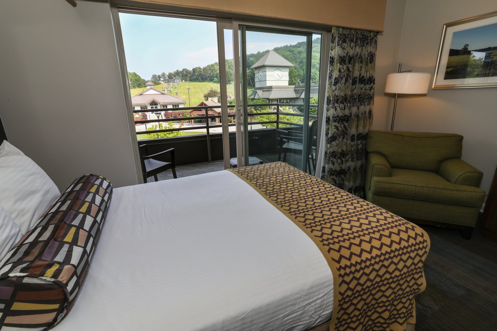 image Bright and airy room with a comfortable bed and direct access to a private balcony with scenic views.