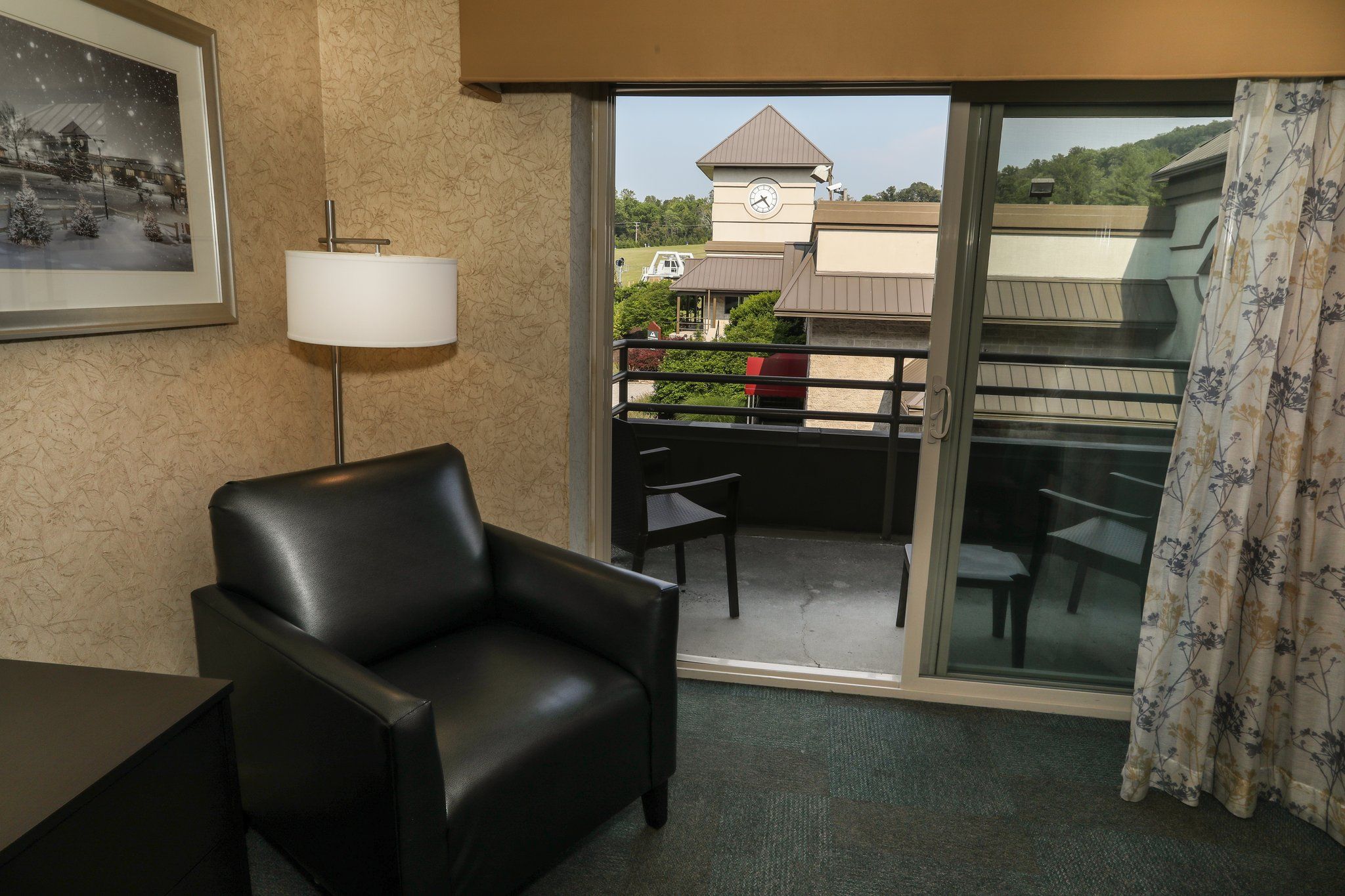image Cozy seating area with a chair and lamp, offering a relaxing space next to the balcony.