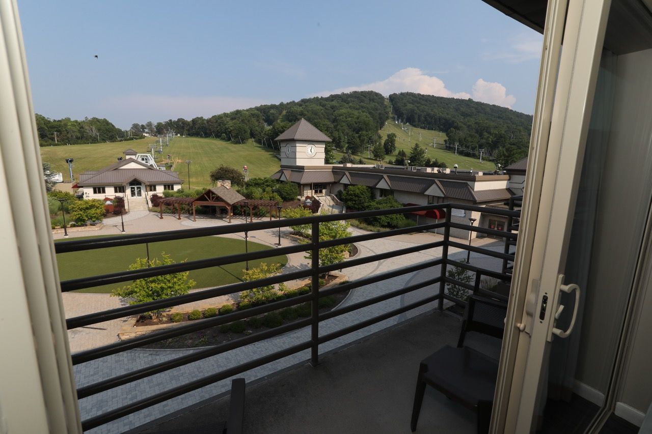 image A peaceful balcony retreat with breathtaking views of rolling green hills and the resort below.