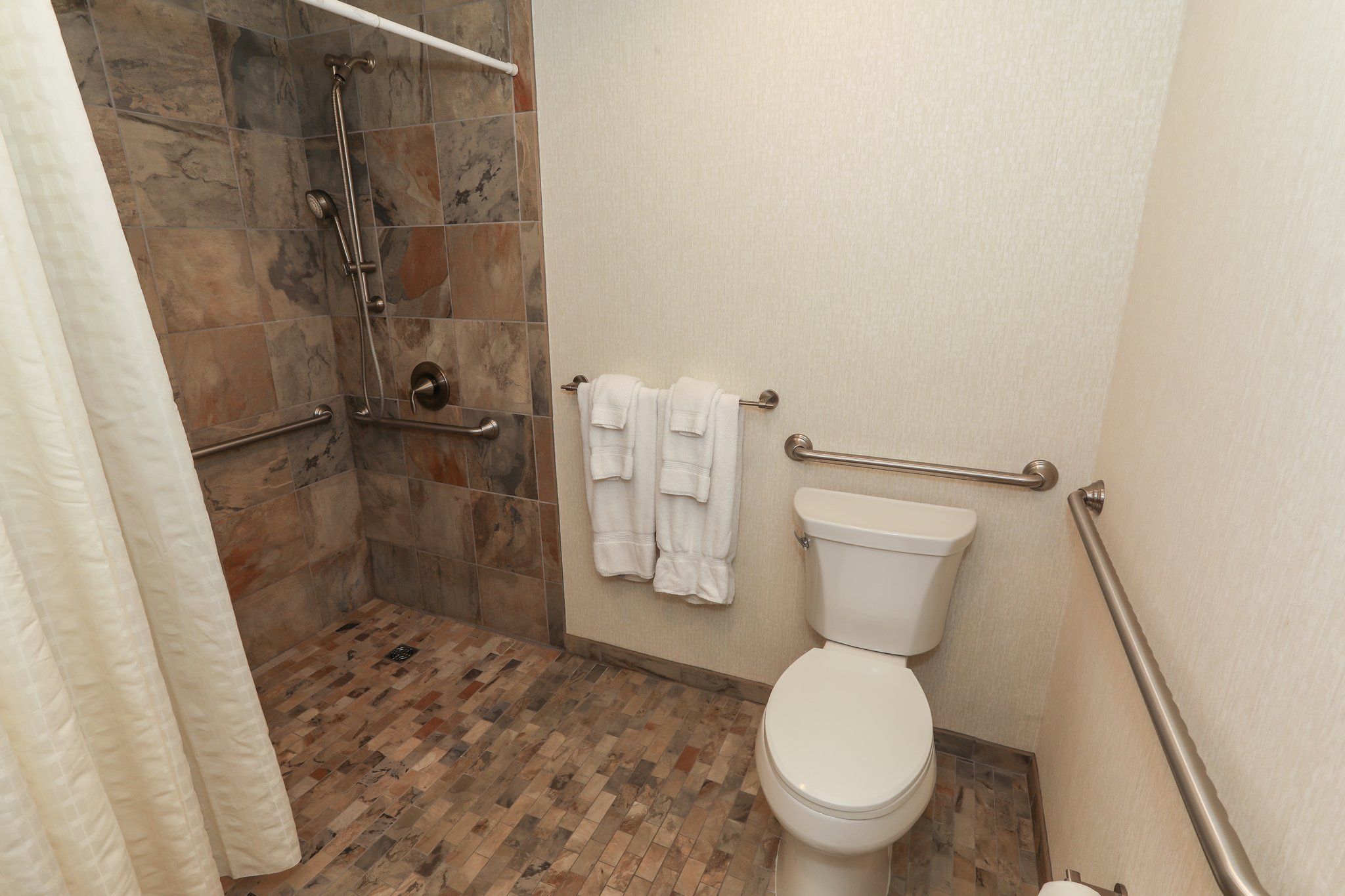 image Modern bathroom with a walk-in shower and fresh towels, offering a relaxing experience.