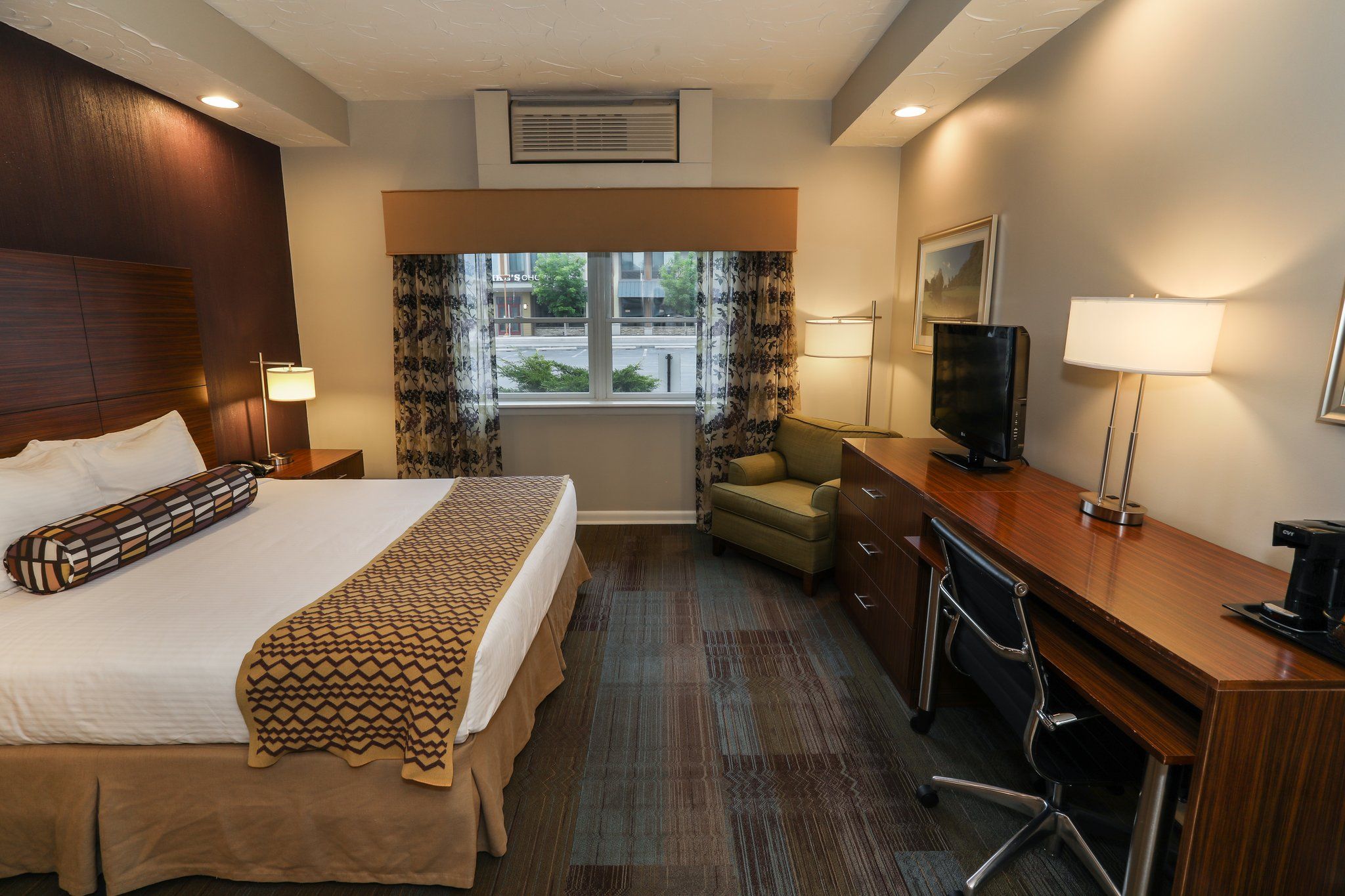 image Comfortable guest room with a plush bed, work desk, and plenty of natural light.