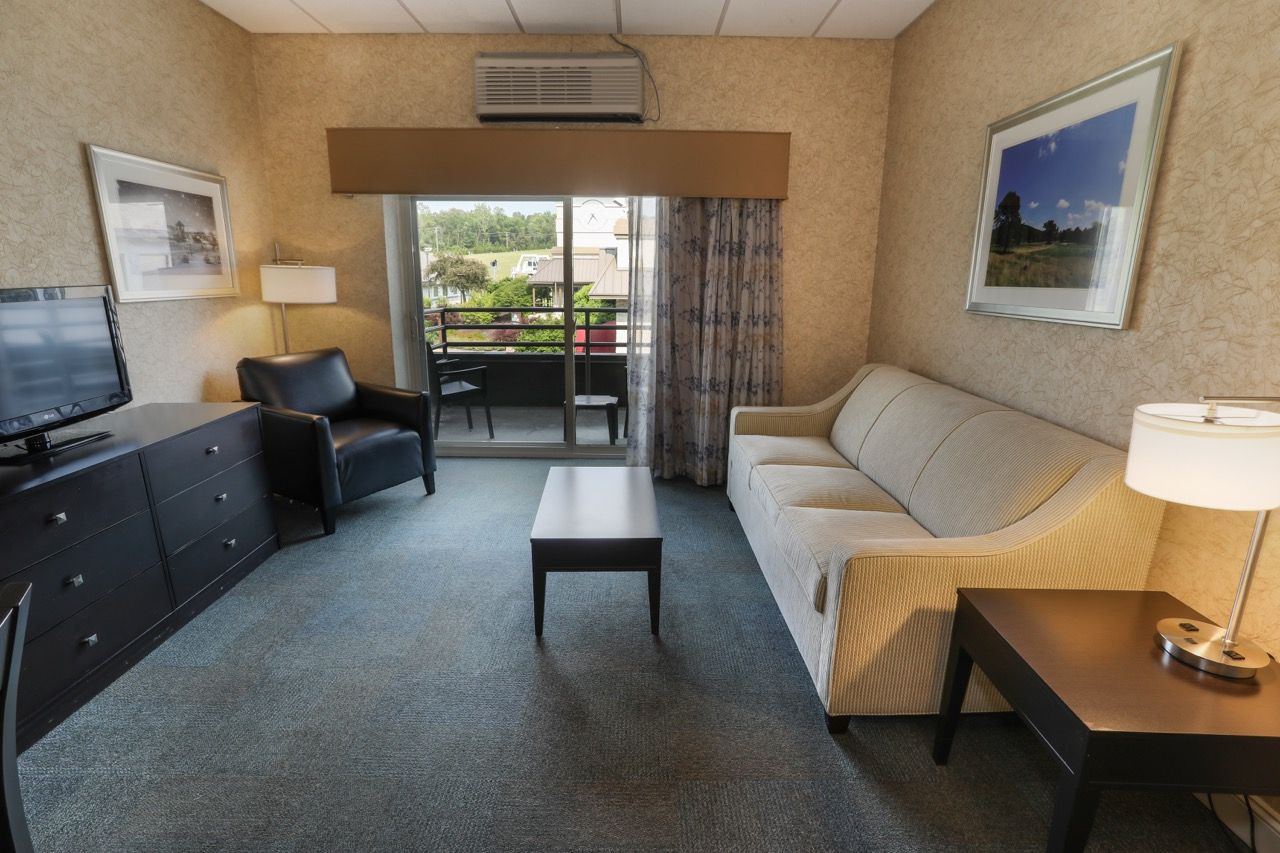 image Spacious living area with comfortable seating and balcony access, ideal for unwinding.