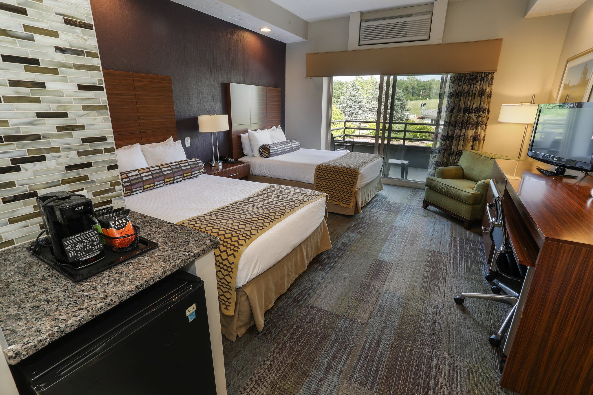 image Stylish guest room with two comfortable beds, modern décor, and a well-equipped kitchenette.