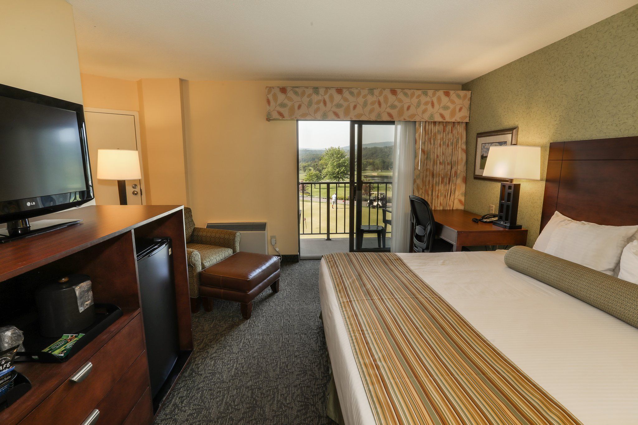 image Cozy guest room with a comfortable bed, TV, and access to a private balcony.