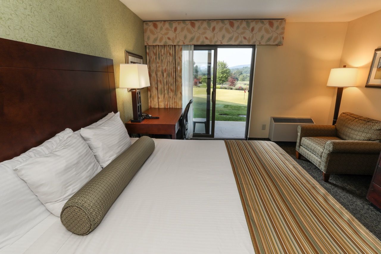 image Cozy guest room with warm décor, plush bedding, and a private patio overlooking scenic views.