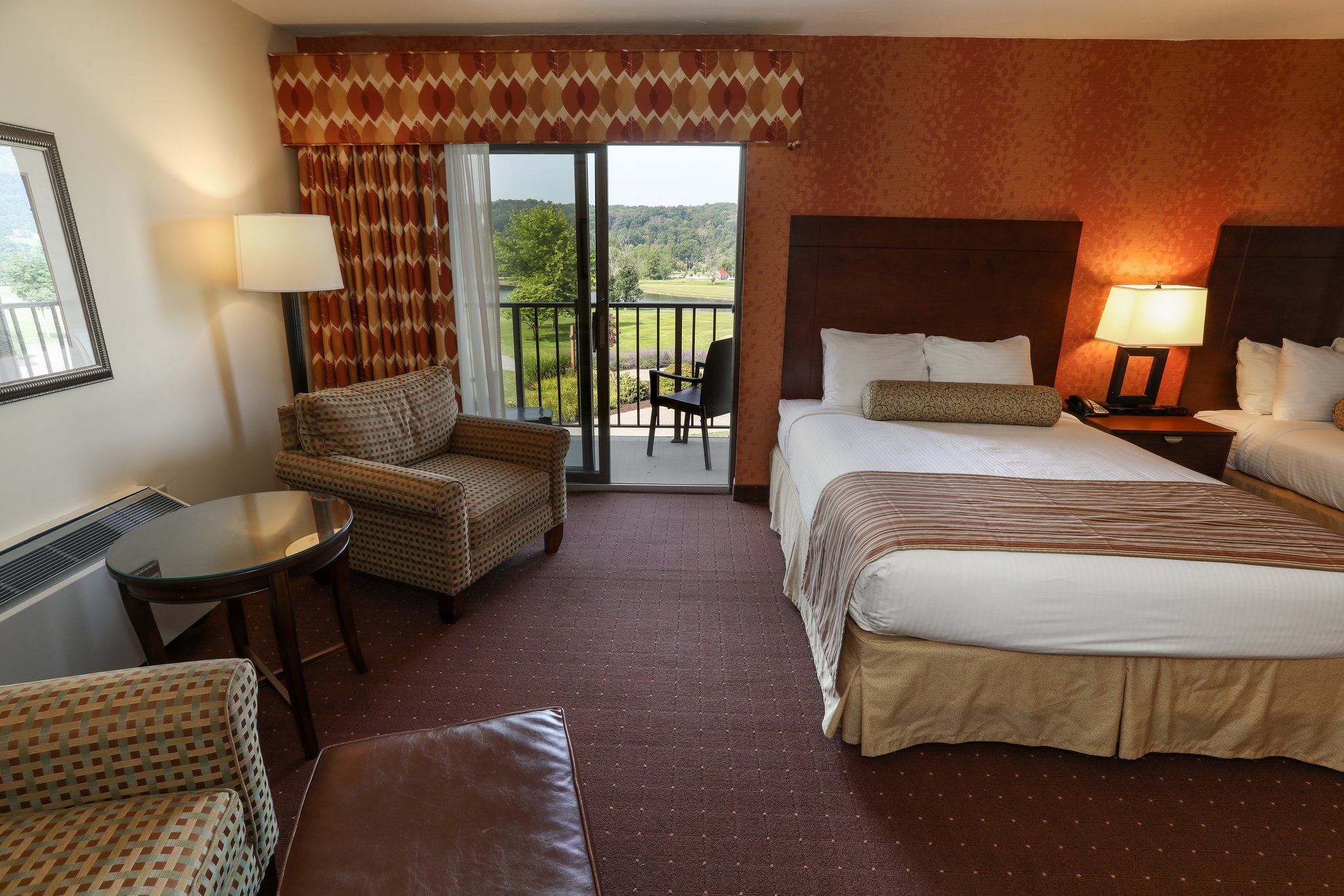 image Spacious guest room with two plush beds and a seating area, offering comfort and relaxation.