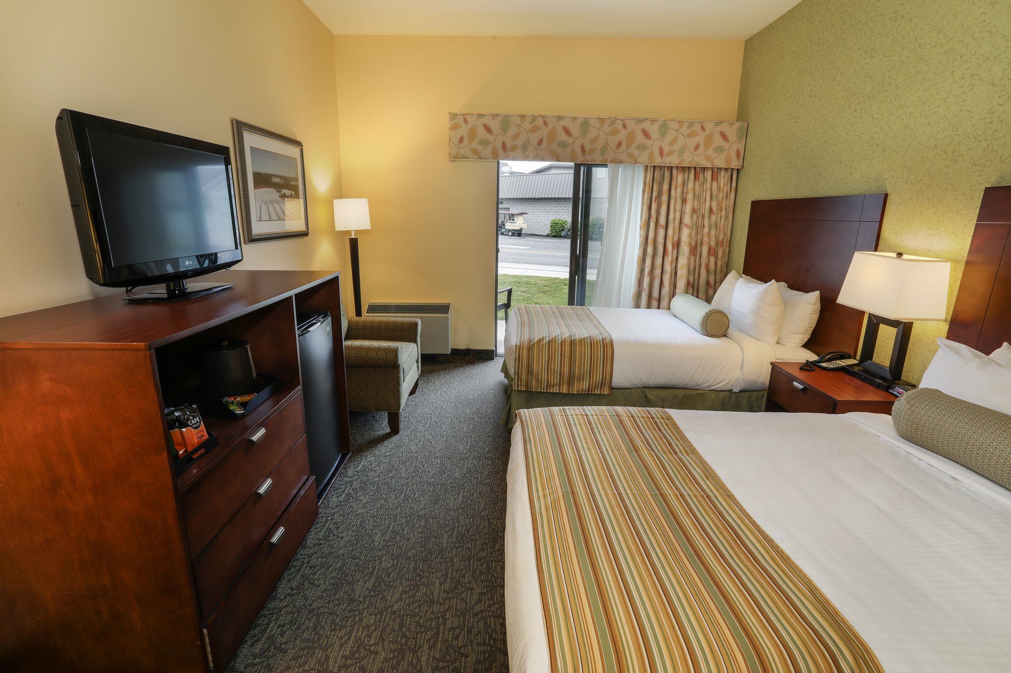 image Cozy guest room with a comfortable bed, TV, and plenty of natural light, perfect for a relaxing stay.