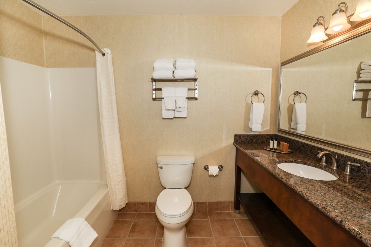 image Modern bathroom with a shower/tub combo and a large vanity, providing comfort and convenience.