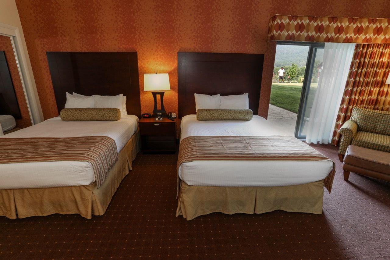 image Spacious room with two plush beds and a private balcony, perfect for families or groups.