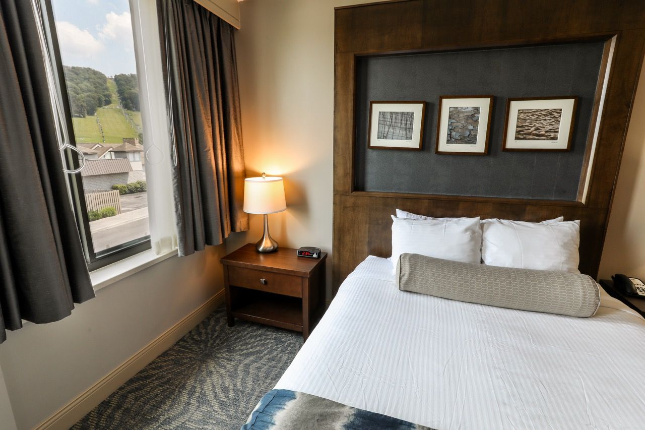 image Cozy room with a comfortable bed and large windows, offering scenic views.