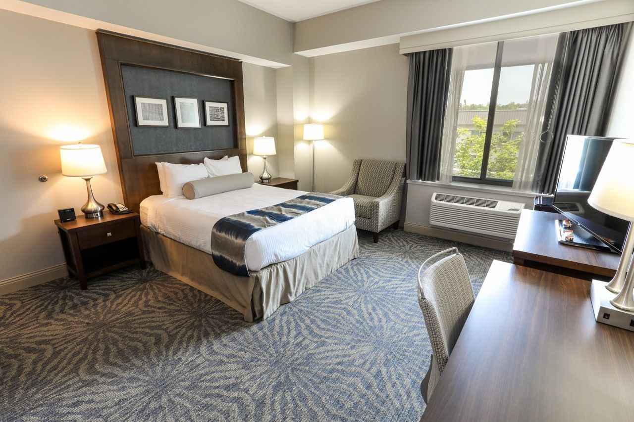 image Bright room featuring a cozy bed and a convenient workspace, perfect for both relaxation and productivity.