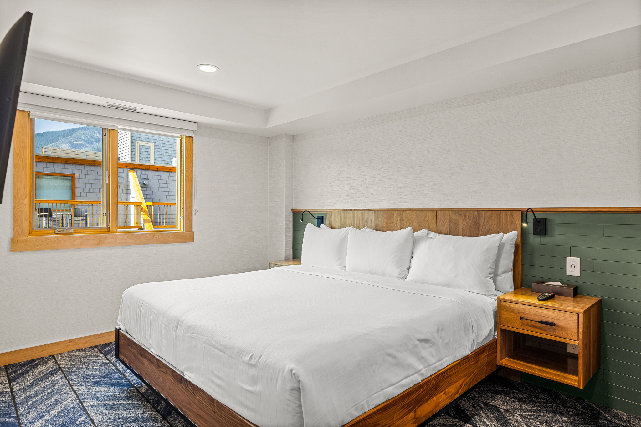 image Bright, modern bedroom with large windows and a comfortable bed for a restful stay.