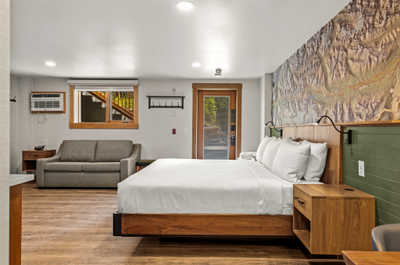Modern and cozy room with a plush bed and additional seating area, perfect for relaxing.