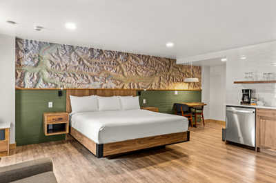 Modern and cozy room with a plush bed and additional seating area, perfect for relaxing.