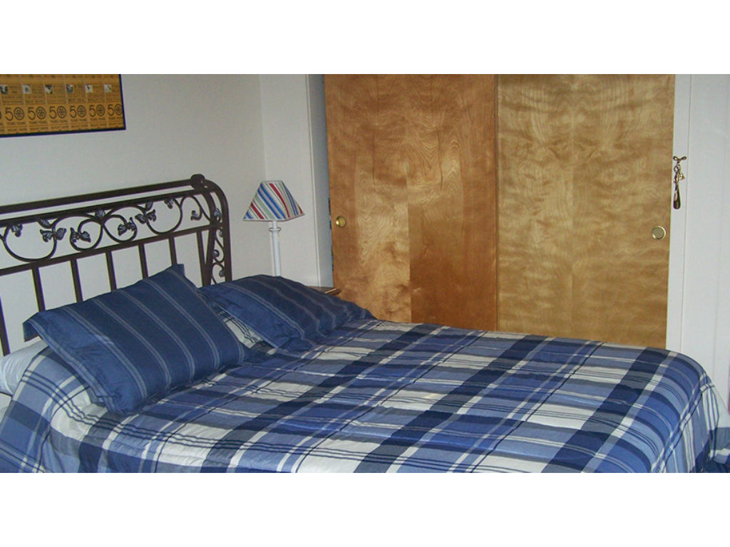 image Features a cozy queen bed with soft linens, ensuring a restful night's sleep.