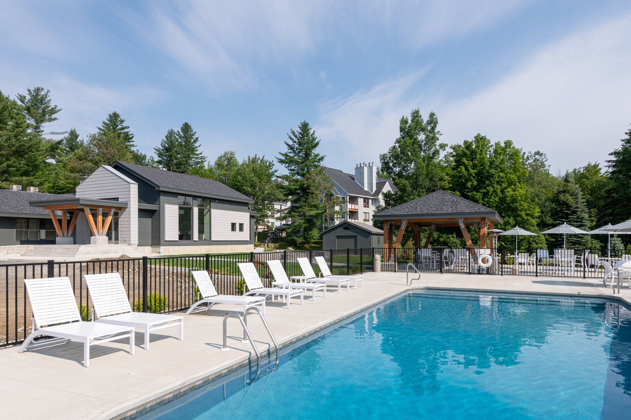 image Pristine outdoor pool area with plenty of lounge seating, perfect for soaking up the sun and enjoying a refreshing swim.