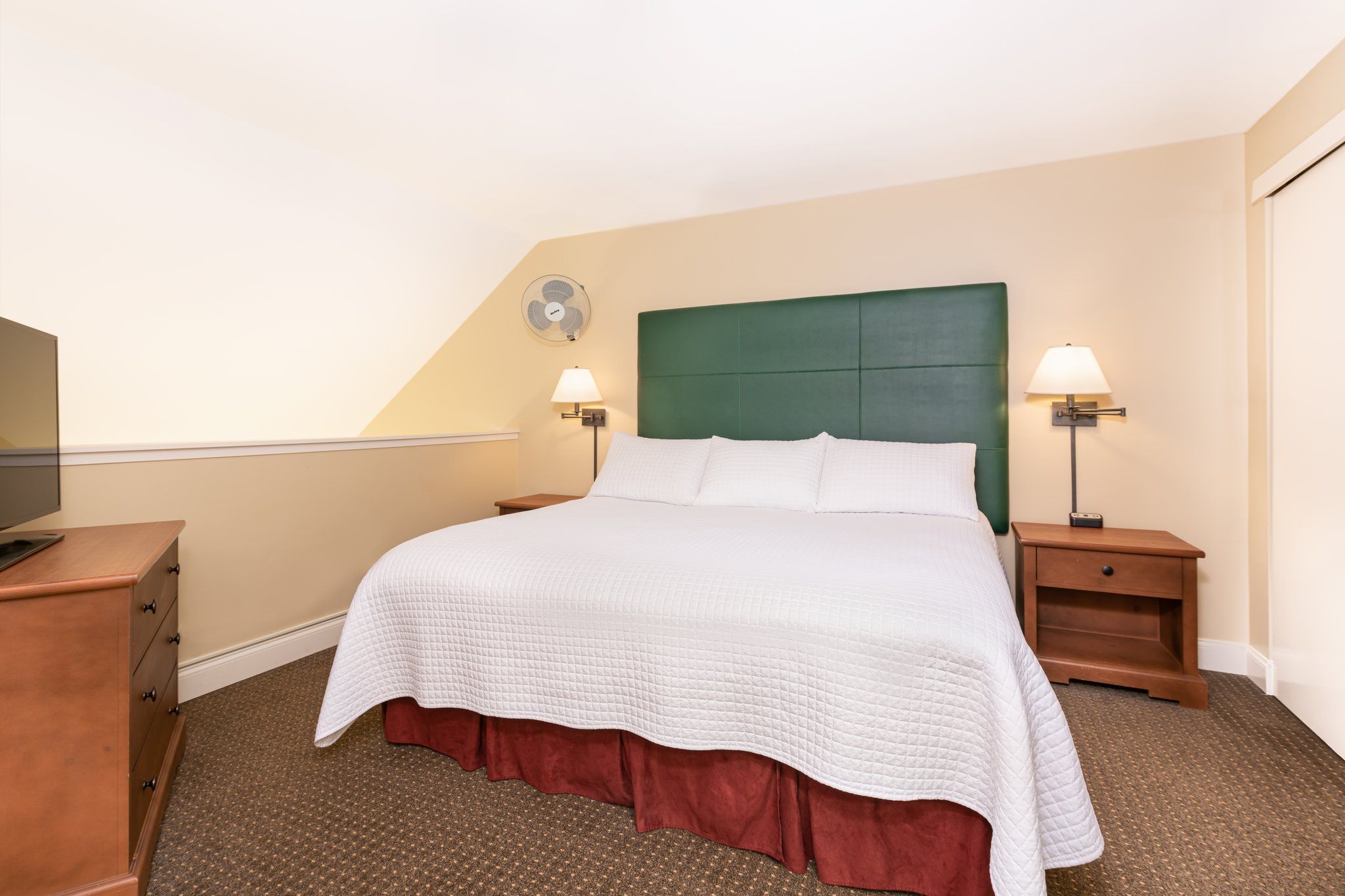 image Unwind in this serene bedroom, where the plush bed and soft lighting create a peaceful ambiance perfect for a rejuvenating night’s rest.