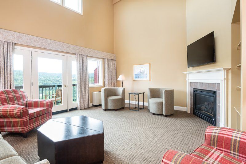 image Bright and spacious living area with high ceilings and large windows, offering a comfortable space to relax and enjoy the view.