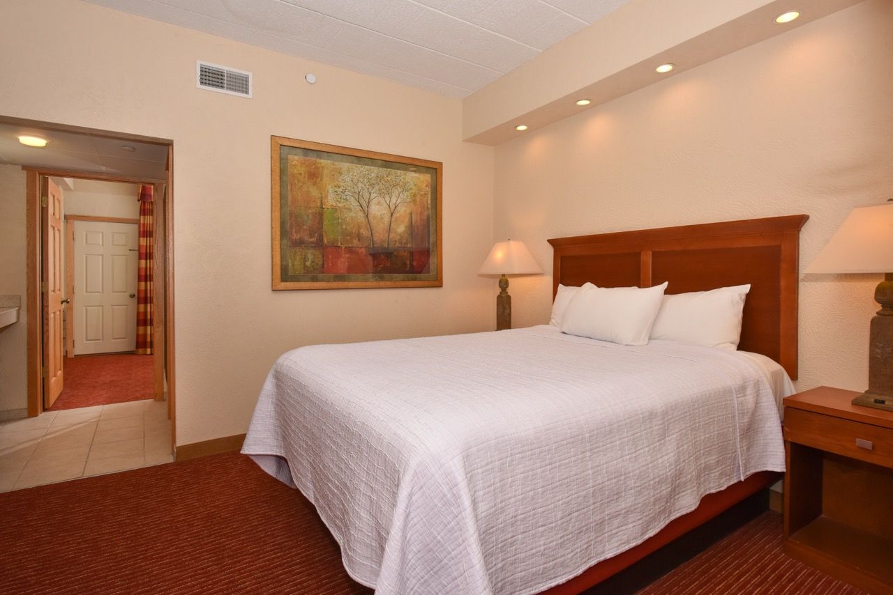 image Elegant bedroom featuring modern accents, a plush bed, and warm lighting for a tranquil and inviting atmosphere.