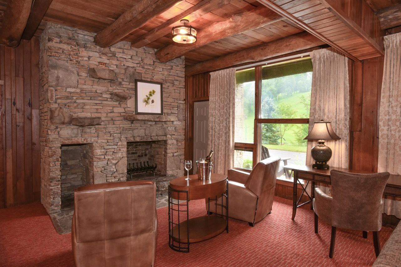 image Cozy living space with a stone fireplace, wooden beams, and inviting furniture, creating a warm, rustic atmosphere.