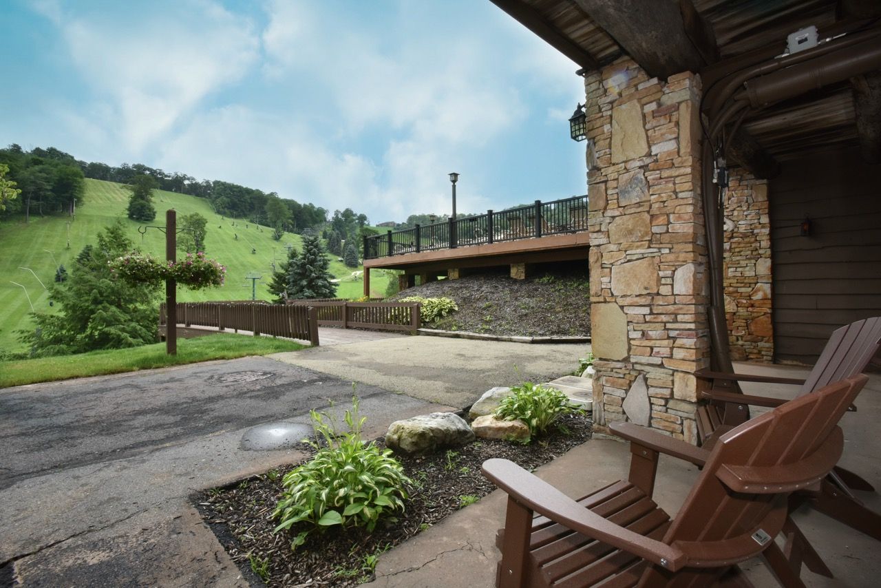 image Covered outdoor seating area with rustic charm and scenic views of lush green hills, perfect for unwinding.