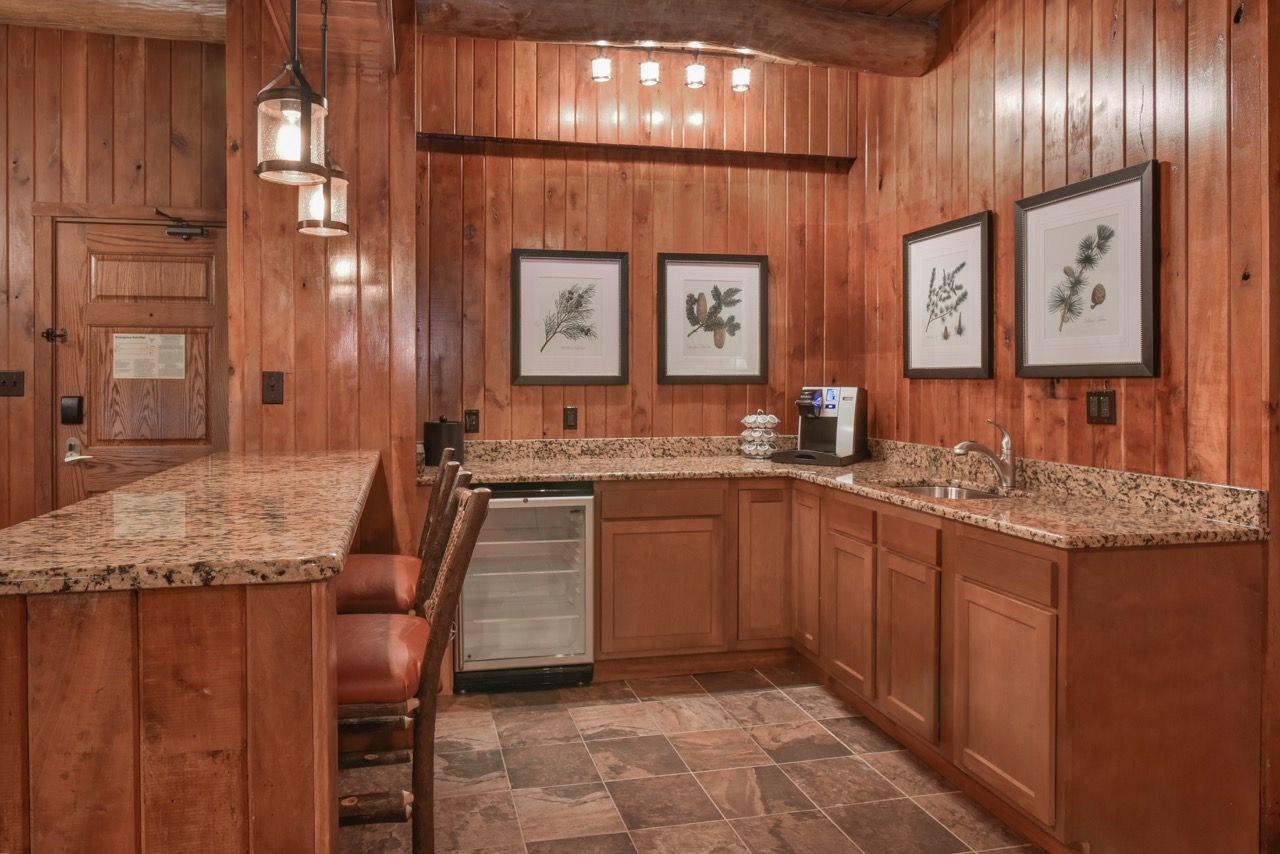 image Charming kitchenette with rich wooden cabinetry, granite countertops, and elegant lighting for a delightful cooking experience.