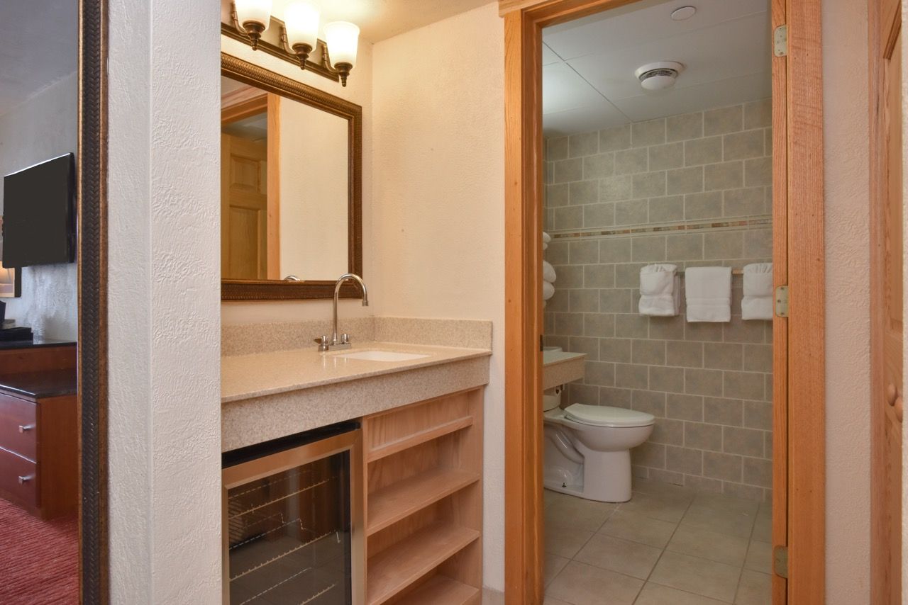 image Modern bathroom with a sleek vanity, tiled walls, and thoughtful amenities for a refreshing experience.