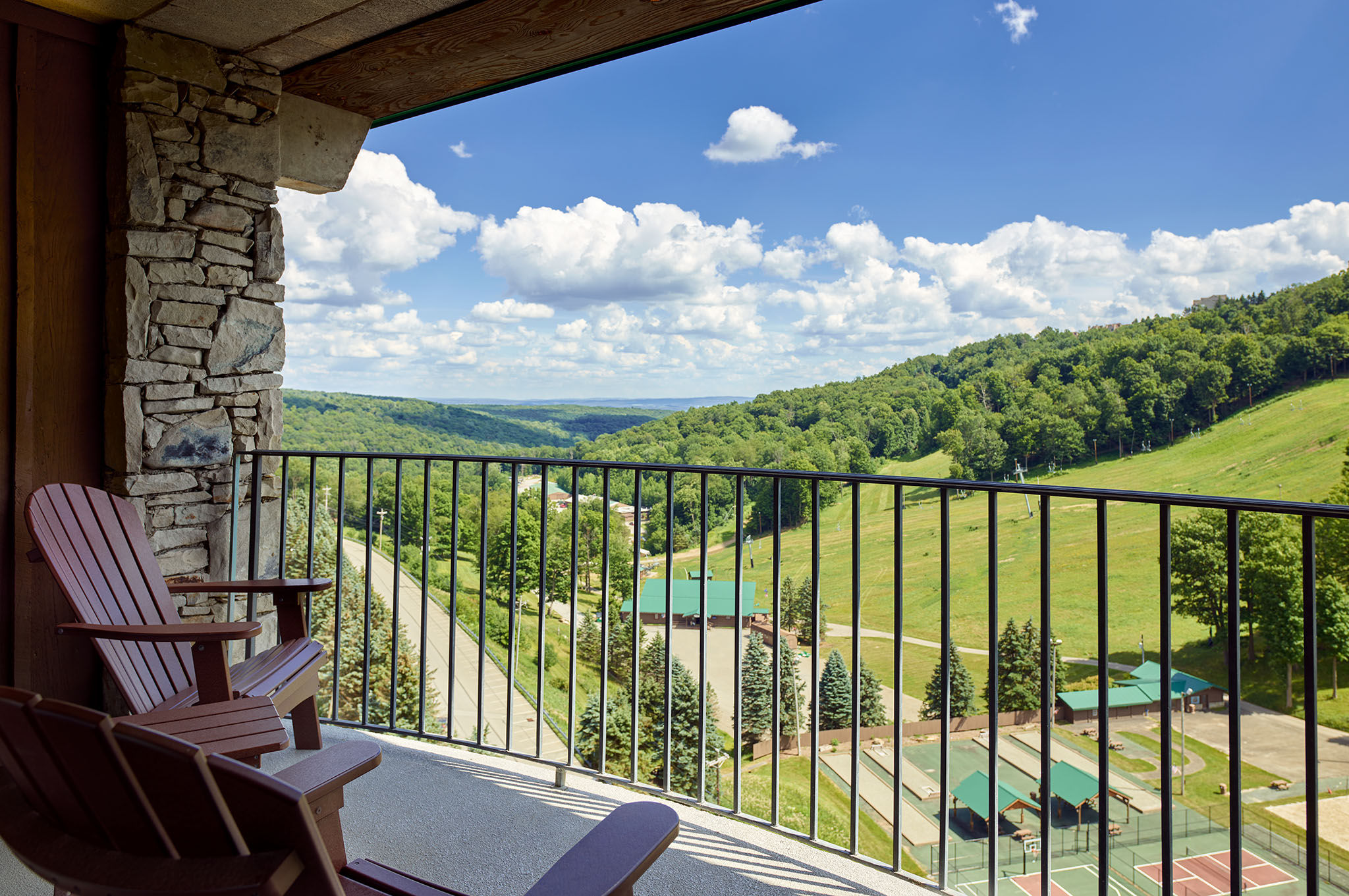 image Private balcony with cozy seating and breathtaking views of rolling green hills and the valley below.