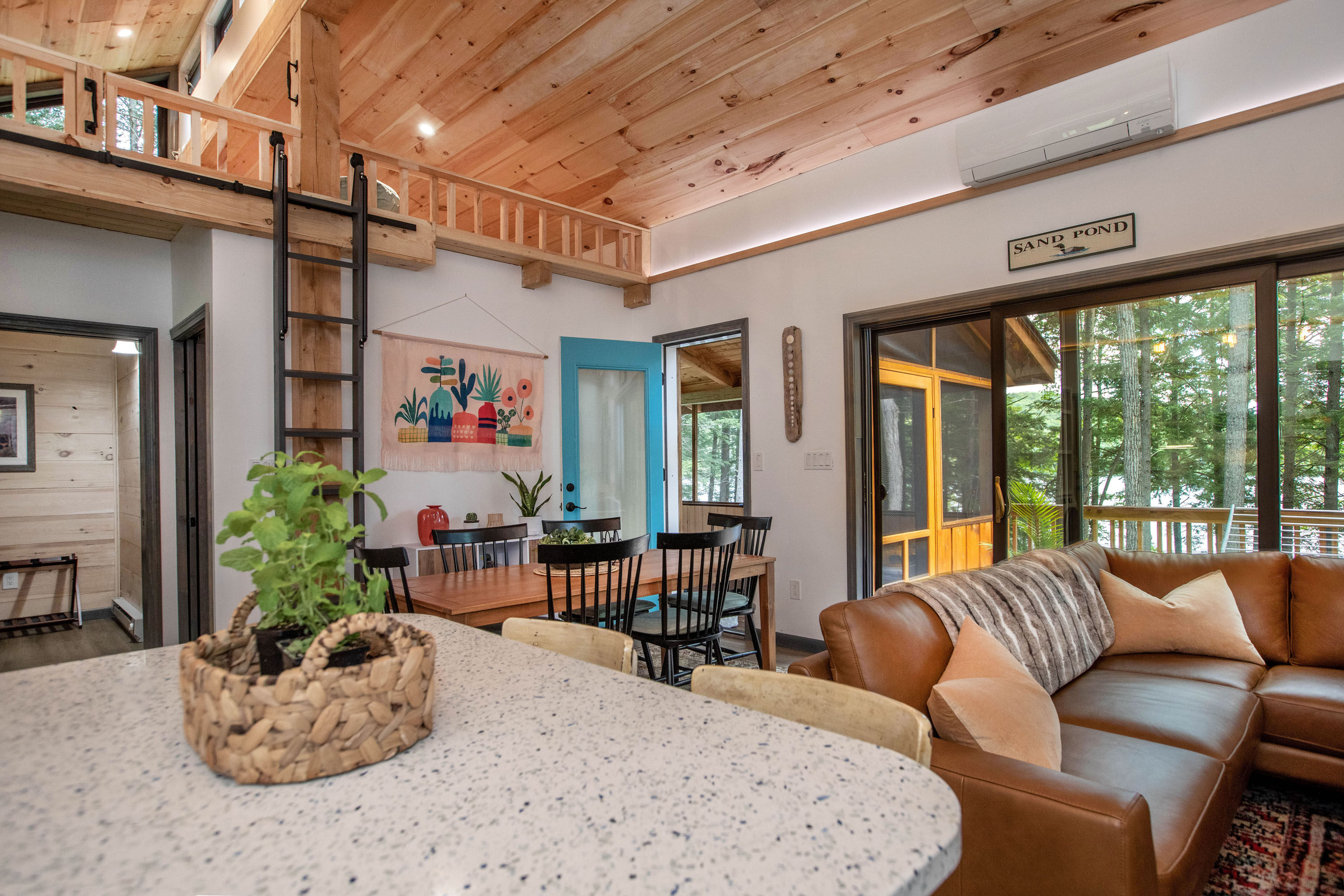 image Open-concept living area with leather seating and dining table, perfect for family meals and relaxation.