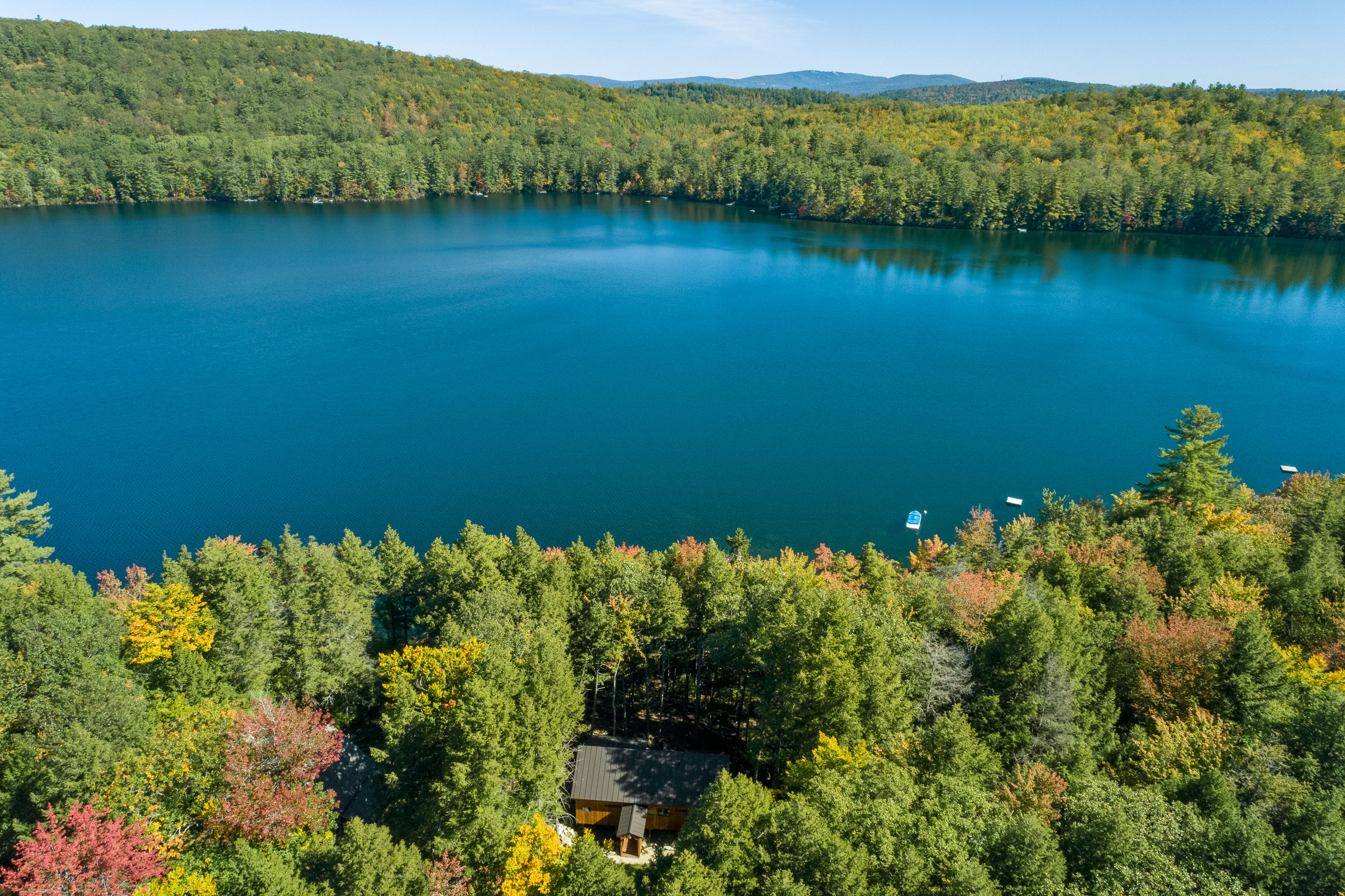 image Stunning aerial view of Norway Lake with Early Birds cabin nestled among vibrant trees—your private lakeside retreat awaits.