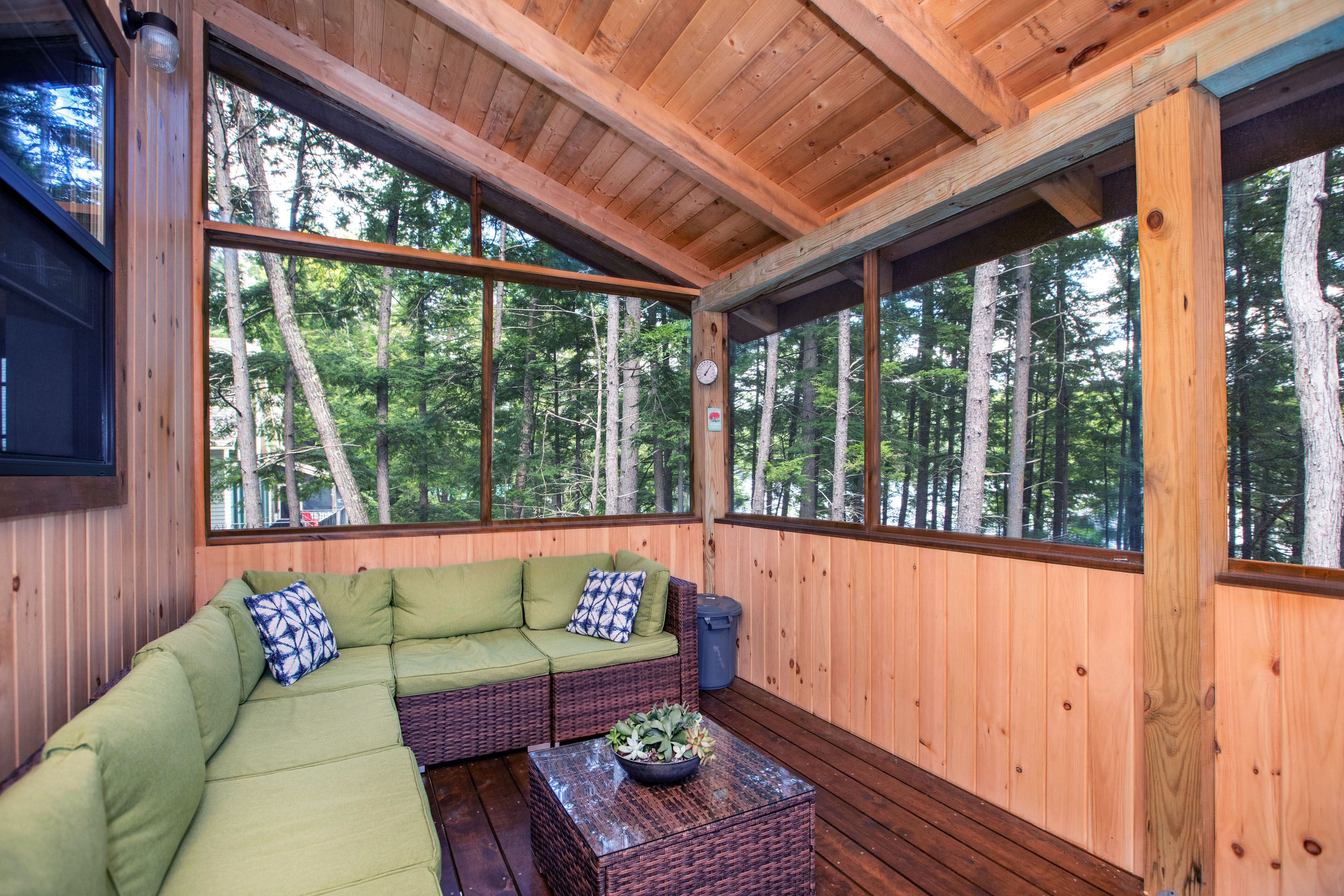 image Comfortable screened-in porch with forest views, ideal for outdoor lounging and enjoying the fresh air.