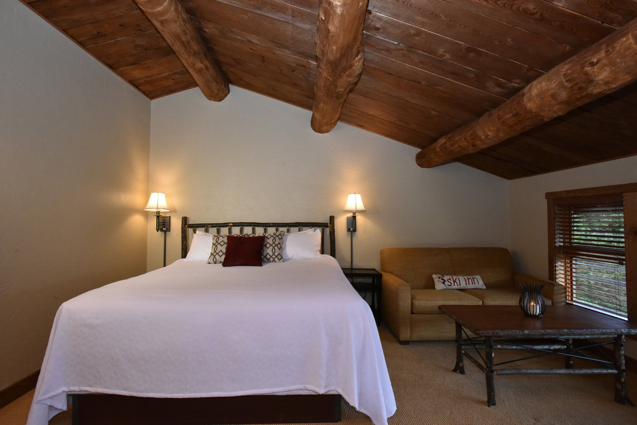 image Cozy bedroom under rustic wooden beams, offering a warm and inviting retreat.