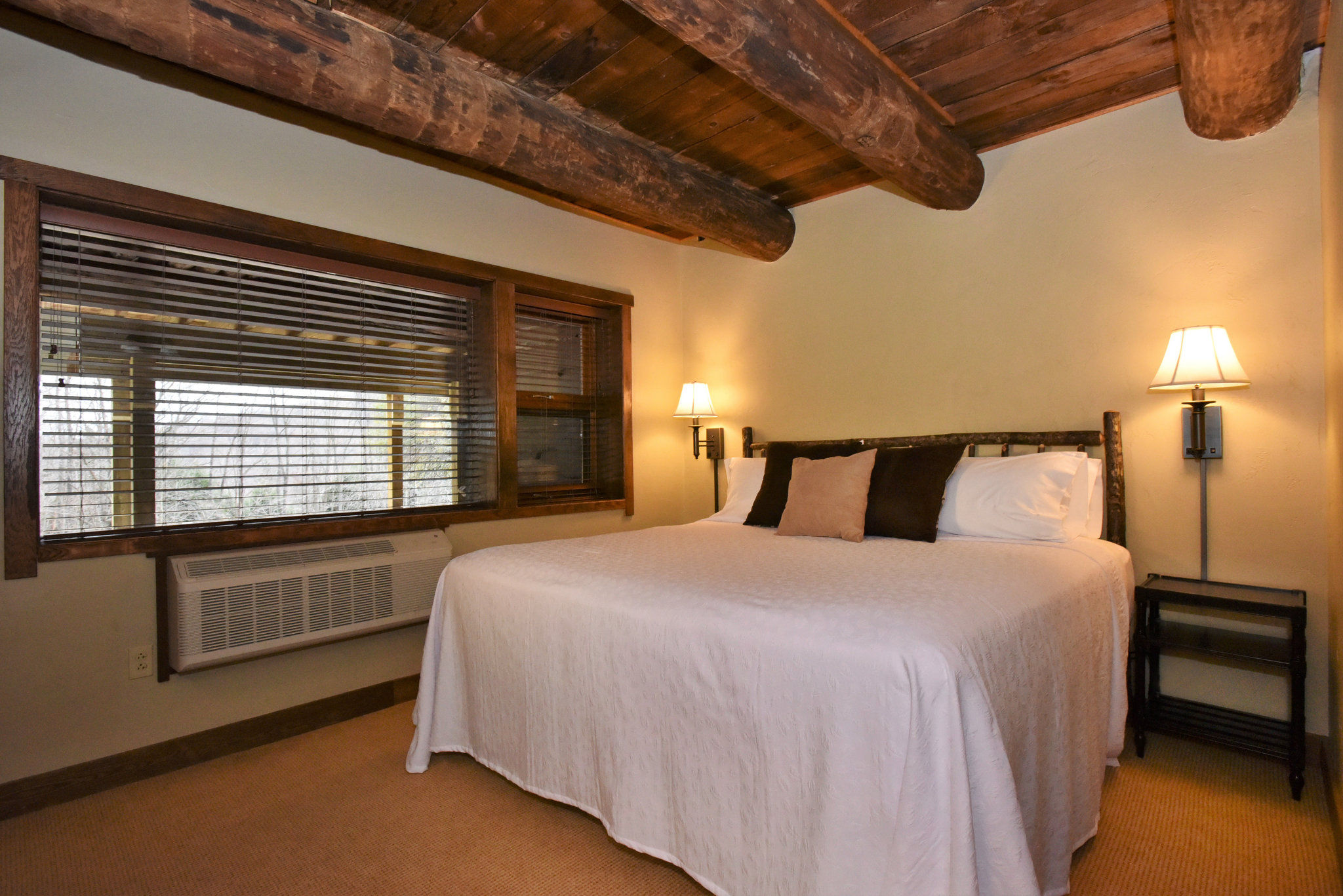 image  Cozy bedroom with wooden beams and soft lighting, providing a peaceful retreat for a restful night.