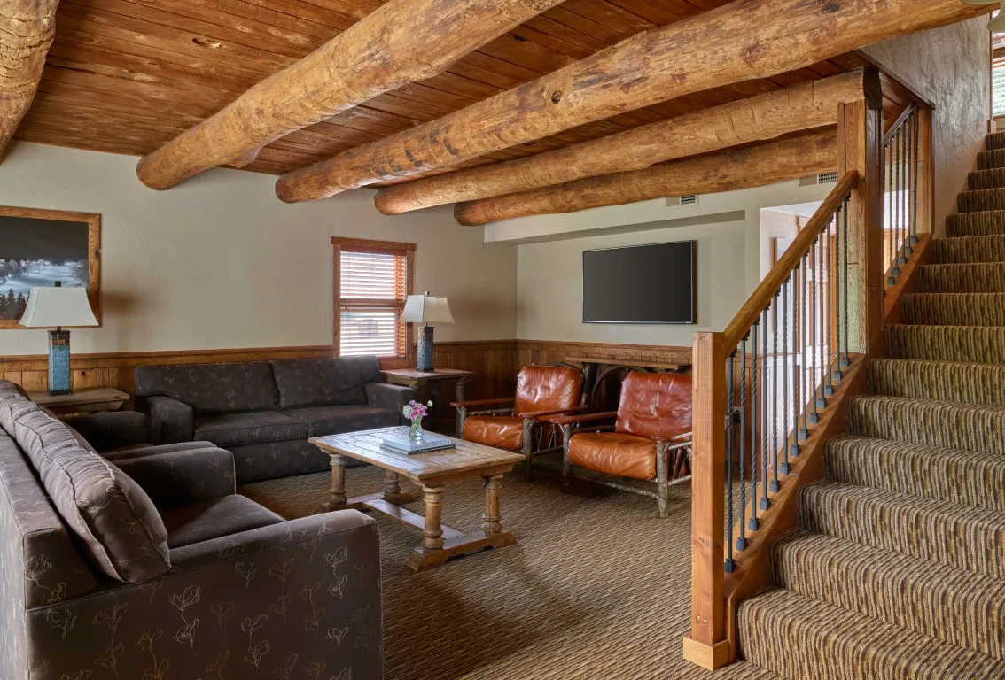 image Spacious living space with rustic beams and cozy seating, perfect for relaxing after a day of exploring.