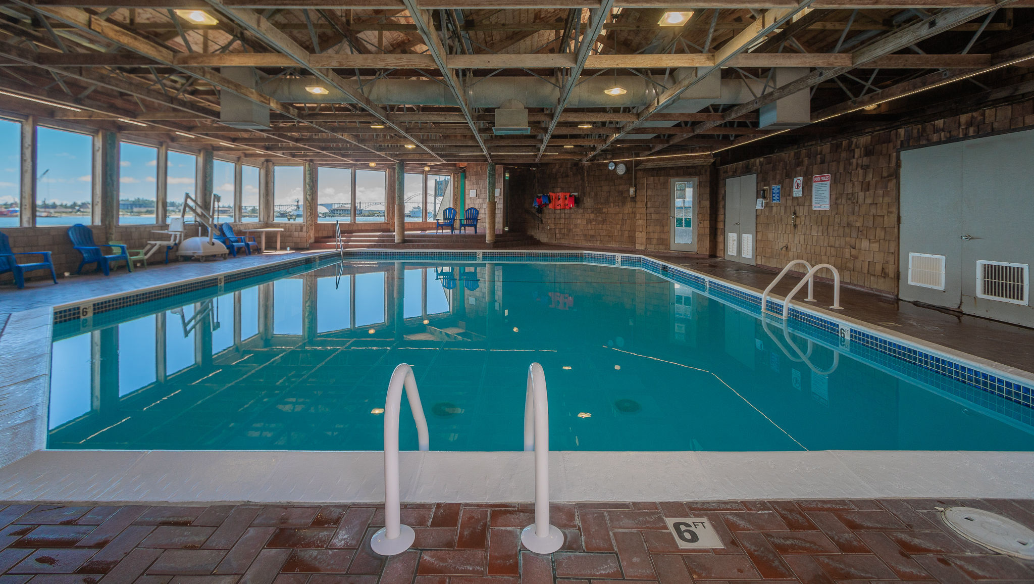image Take a refreshing dip in this inviting indoor pool, surrounded by warm lighting and an open, airy atmosphere—perfect for relaxation no matter the season.