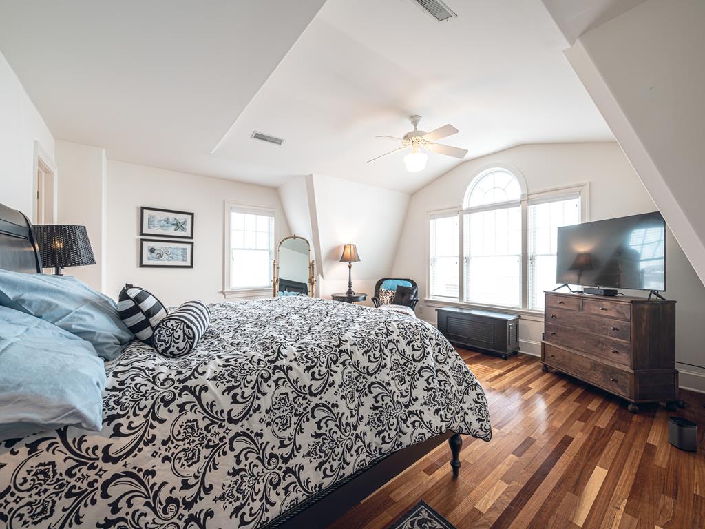 image Luxurious master bedroom with a king-size bed, vaulted ceilings, and a large TV for ultimate comfort and relaxation.