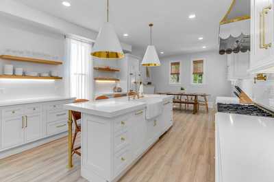 Wide-angle view of the kitchen showcasing the open layout, abundant storage, and sleek finishes.