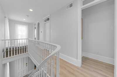 Elegant hallway with natural light and a view of the open staircase for a seamless flow between floors.