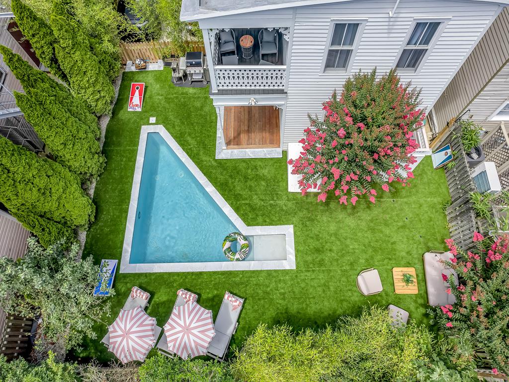 image Private backyard oasis featuring a heated pool, sun loungers, and lush greenery for a serene outdoor escape.