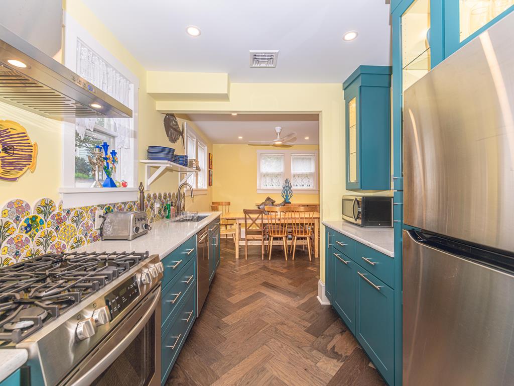 image Fully equipped kitchen with vibrant cabinetry, stainless steel appliances, and eye-catching backsplash – perfect for preparing meals during your stay.