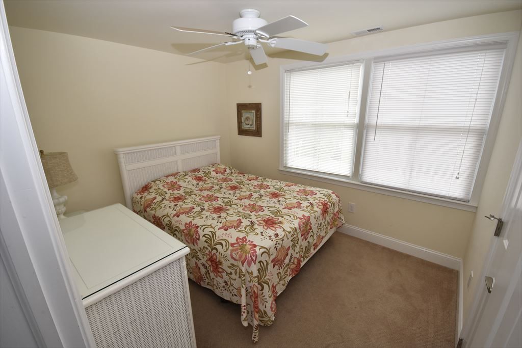 image Cozy bedroom with a queen-sized bed, ceiling fan, and soft, neutral decor for a restful night’s sleep.